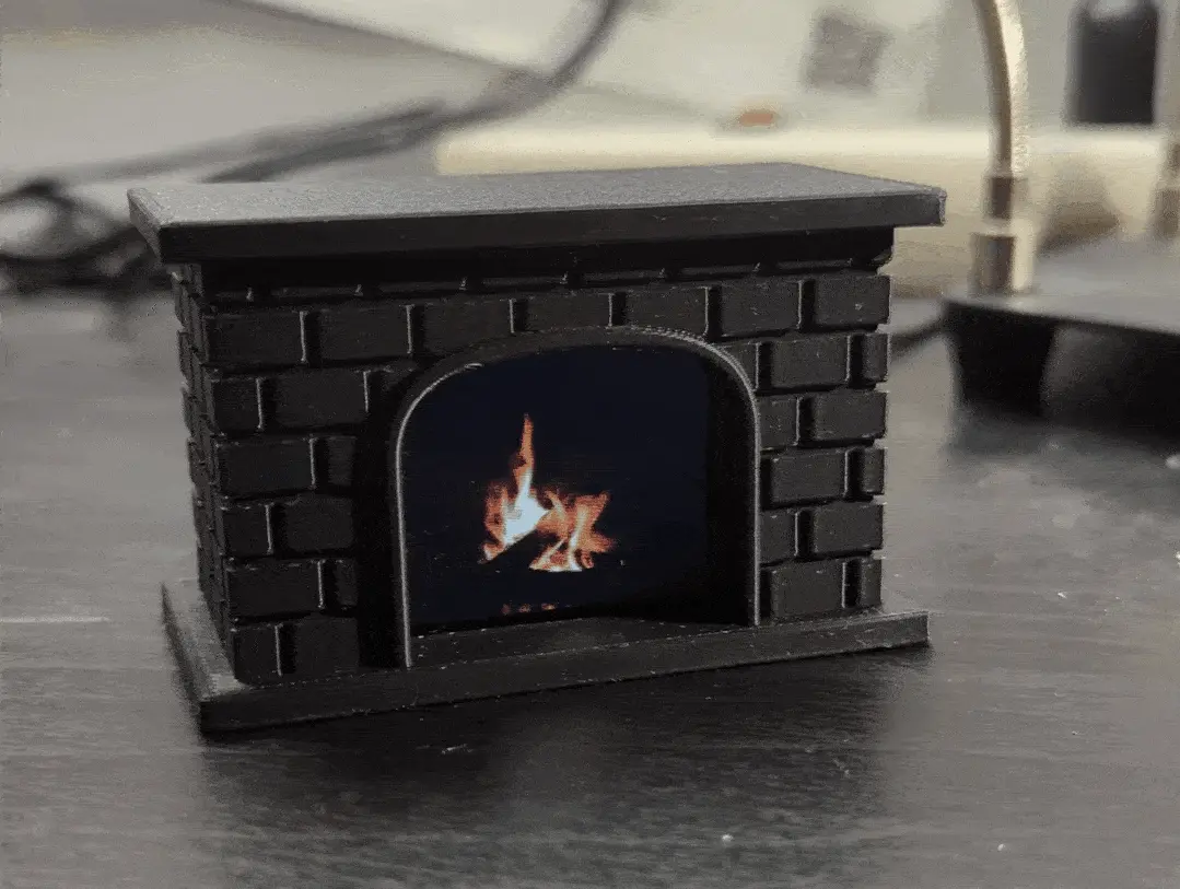 An animated picture of an all-black plastic fireplace with a little screen inside playing a fireplace animation.